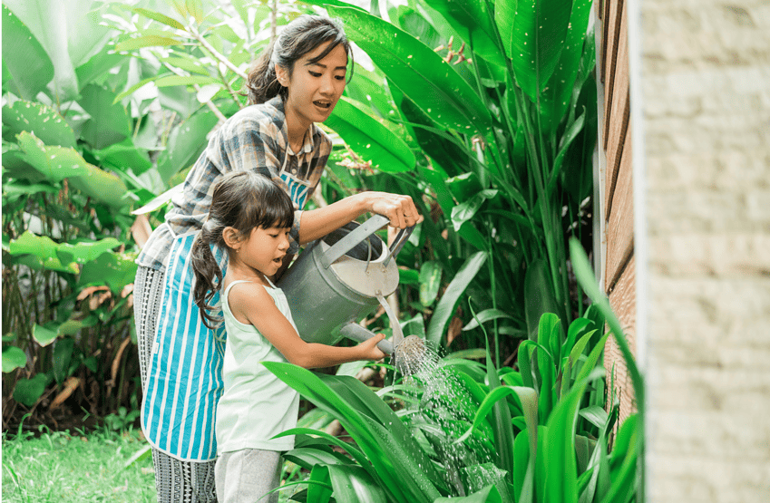 woman and child watering outdoor plants